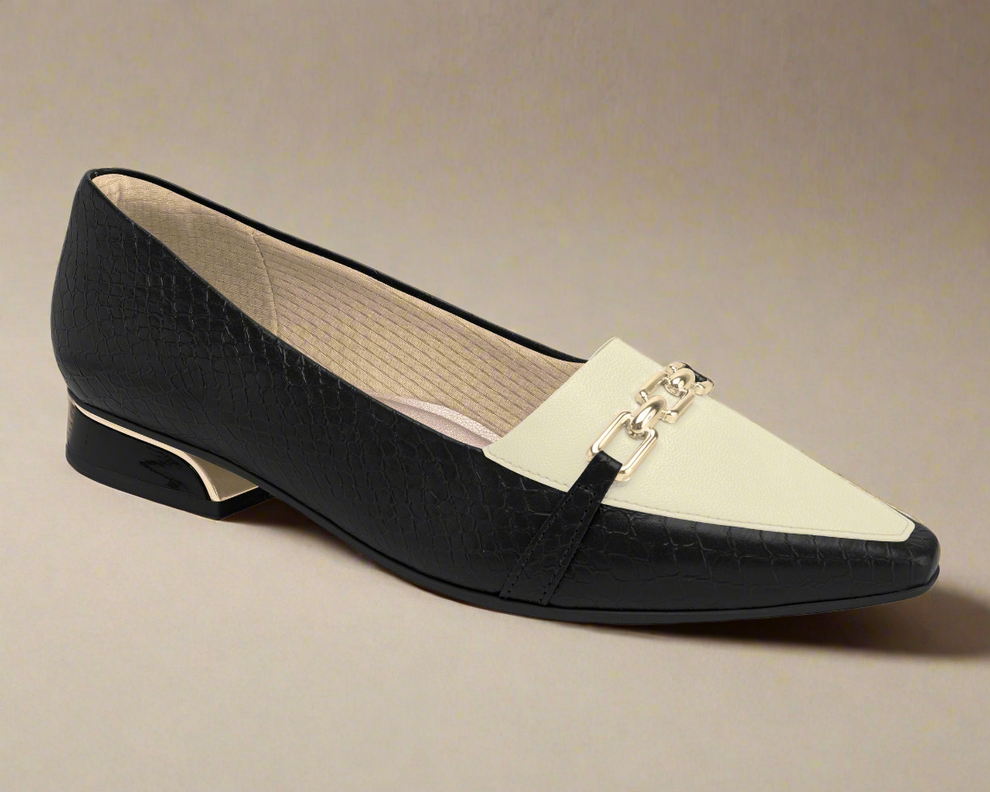 Black and white loafer shoe on a beige background